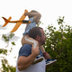 Playing with toy plane, sitting on father's shoulders. Happy family father and son playing and laugh Playing with toy plane, sitting on father's shoulders. Happy family father and son playing and laugh - PhotoDune Item for Sale