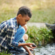 Children playing near little river in forest, wetting hands, taking stones. Warm sunny day activity Children playing near little river in forest, wetting hands, taking stones. Warm sunny day activity - PhotoDune Item for Sale