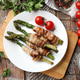 Tasty asparagus wrapped in bacon and tomatoes on wooden table, flat lay Tasty asparagus wrapped in bacon and tomatoes on wooden table, flat lay - PhotoDune Item for Sale