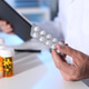 Pharmacist holding blister with pills at white table in clinic, closeup Pharmacist holding blister with pills at white table in clinic, closeup - PhotoDune Item for Sale