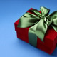 Red gift box with satin bow on blue background. Space for text Red gift box with satin bow on blue background. Space for text - PhotoDune Item for Sale