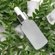 Bottle of cosmetic oil, ice cubes and green leaves on white table, flat lay Bottle of cosmetic oil, ice cubes and green leaves on white table, flat lay - PhotoDune Item for Sale
