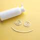 Smiling face made of sunscreen and bottle of protection cream on yellow background, closeup Smiling face made of sunscreen and bottle of protection cream on yellow background, closeup - PhotoDune Item for Sale