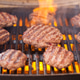Burger patties grilling with fire and smoke Burger patties grilling with fire and smoke - PhotoDune Item for Sale