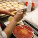 Middle aged Asian woman brushing egg wash on pastry tarts in a busy commercial bakery kitchen Middle aged Asian woman brushing egg wash on pastry tarts in a busy commercial bakery kitchen - PhotoDune Item for Sale