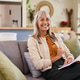 Smiling senior woman looking at camera while relaxing at home Smiling senior woman looking at camera while relaxing at home - PhotoDune Item for Sale