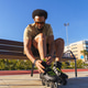 Young latino man preparing rollerblade for city skating Young latino man preparing rollerblade for city skating - PhotoDune Item for Sale