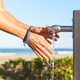 Person washing hands at outdoor beach faucet Person washing hands at outdoor beach faucet - PhotoDune Item for Sale