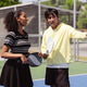 Pickleball doubles partners discussing game strategy on outdoor court. Man gesturing to woman player Pickleball doubles partners discussing game strategy on outdoor court. Man gesturing to woman player - PhotoDune Item for Sale