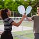Pickleball doubles team celebrating victory on outdoor court. Smiling man and woman greeting with pa Pickleball doubles team celebrating victory on outdoor court. Smiling man and woman greeting with pa - PhotoDune Item for Sale