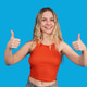 Young woman giving thumbs up gesture smiling Young woman giving thumbs up gesture smiling - PhotoDune Item for Sale