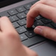 A young man typing on a modern laptop keyboard while studying, coding, or working on an IT project. A young man typing on a modern laptop keyboard while studying, coding, or working on an IT project. - PhotoDune Item for Sale