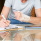 Woman filling out medical report with hand orthotic splint Woman filling out medical report with hand orthotic splint - PhotoDune Item for Sale