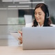 Woman wearing headphones, participating in online conference call, taking notes with laptop in a mod Woman wearing headphones, participating in online conference call, taking notes with laptop in a mod - PhotoDune Item for Sale