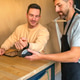 Young male making contactless smartwatch payment on a terminal held by waiter on cafe Young male making contactless smartwatch payment on a terminal held by waiter on cafe - PhotoDune Item for Sale