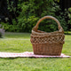 Empty wicker picnic basket on blanket in green garden with copy space Empty wicker picnic basket on blanket in green garden with copy space - PhotoDune Item for Sale