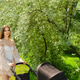 Young woman walks in park with stroller enjoying sunny day under trees Young woman walks in park with stroller enjoying sunny day under trees - PhotoDune Item for Sale