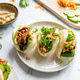 Steamed bao buns filled with chicken and sweet teriyaki sauce on a plate. Steamed bao buns filled with chicken and sweet teriyaki sauce on a plate. - PhotoDune Item for Sale