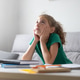 Thoughtful schoolgirl looking up while studying at home Thoughtful schoolgirl looking up while studying at home - PhotoDune Item for Sale