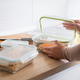 Woman opening a healthy salmon meal prep container in the kitchen Woman opening a healthy salmon meal prep container in the kitchen - PhotoDune Item for Sale