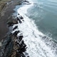 Aerial view of breaking waves on a rocky dark sand coastline Aerial view of breaking waves on a rocky dark sand coastline - PhotoDune Item for Sale