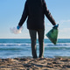 Person picking up waste from ocean beach. unrecognizable person Person picking up waste from ocean beach. unrecognizable person - PhotoDune Item for Sale