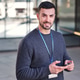 Smiling man wearing security badge using mobile phone Smiling man wearing security badge using mobile phone - PhotoDune Item for Sale