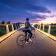 Female cyclist with road bike on illuminated bridge at sunset Female cyclist with road bike on illuminated bridge at sunset - PhotoDune Item for Sale