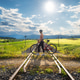 Female cyclist riding mountain bike and rural railroad at sunset Female cyclist riding mountain bike and rural railroad at sunset - PhotoDune Item for Sale