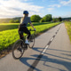 Female cyclist with road bike riding on asphalt path at sunset Female cyclist with road bike riding on asphalt path at sunset - PhotoDune Item for Sale