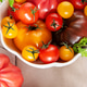Fresh organic heirloom tomatoes in white bowl Fresh organic heirloom tomatoes in white bowl - PhotoDune Item for Sale