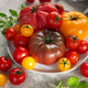 Fresh organic heirloom tomatoes creating colorful healthy food display Fresh organic heirloom tomatoes creating colorful healthy food display - PhotoDune Item for Sale