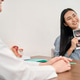 Asian woman consulting with medical professional in exam room Asian woman consulting with medical professional in exam room - PhotoDune Item for Sale
