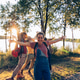 Young friends embracing nature by a lake at sunset Young friends embracing nature by a lake at sunset - PhotoDune Item for Sale