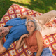 Senior couple relaxing on picnic blanket in garden Senior couple relaxing on picnic blanket in garden - PhotoDune Item for Sale