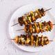 Close up of meat and potatoes baked on skewers in an air fryer on a plate on the table top view Close up of meat and potatoes baked on skewers in an air fryer on a plate on the table top view - PhotoDune Item for Sale