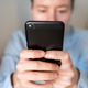 Woman in blue shirt scrolling smartphone after work Woman in blue shirt scrolling smartphone after work - PhotoDune Item for Sale