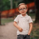 Young boy wearing glasses smiling in park Young boy wearing glasses smiling in park - PhotoDune Item for Sale