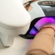 Woman's hand curing gel nails with uv lamp Woman's hand curing gel nails with uv lamp - PhotoDune Item for Sale