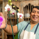 Garden center owner presenting beautiful white orchid Garden center owner presenting beautiful white orchid - PhotoDune Item for Sale