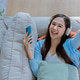 Woman listen to music on the mobile phone lying on a sofa in the living room. Woman listening music Woman listen to music on the mobile phone lying on a sofa in the living room. Woman listening music - PhotoDune Item for Sale