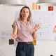 Mid-adult woman presenting blueprint and swatches in studio, gesturing with hands, pink blouse Mid-adult woman presenting blueprint and swatches in studio, gesturing with hands, pink blouse - PhotoDune Item for Sale