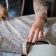 Fashion designer hands inspecting knitted fabric sample with pencil marking details on workspace tab Fashion designer hands inspecting knitted fabric sample with pencil marking details on workspace tab - PhotoDune Item for Sale