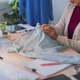 Asian woman online merchant inspecting light blue garment quality while preparing customer order at Asian woman online merchant inspecting light blue garment quality while preparing customer order at - PhotoDune Item for Sale