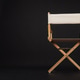 A wooden director’s chair with a light canvas seat on a dark background A wooden director’s chair with a light canvas seat on a dark background - PhotoDune Item for Sale