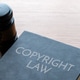 A black gavel and a book titled Copyright Law on a wooden desk. A black gavel and a book titled Copyright Law on a wooden desk. - PhotoDune Item for Sale