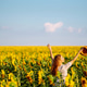 Woman strolling through field with sunflowers. Fashion, lifestyle, travel and vacations concept. Woman strolling through field with sunflowers. Fashion, lifestyle, travel and vacations concept. - PhotoDune Item for Sale