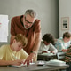 Middle Aged Male Teacher Guiding Teen Boy during Classwork Middle Aged Male Teacher Guiding Teen Boy during Classwork - PhotoDune Item for Sale
