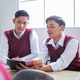 Two Male High School Student in Vest Uniforms Discussing Lesson Together. Asian Classmates Studying Two Male High School Student in Vest Uniforms Discussing Lesson Together. Asian Classmates Studying - PhotoDune Item for Sale
