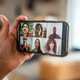 Hand holding smartphone displaying diverse group video call Hand holding smartphone displaying diverse group video call - PhotoDune Item for Sale